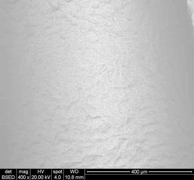 Scanning electron microscope image of the MSDI SLA implant surface at 400× magnification, showing overlapping craters and finer etched texture. Scale bar 400 micrometres.
